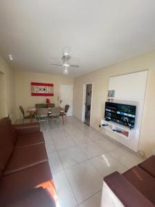 - un salon avec un canapé, une télévision et une table dans l'établissement Apartamento Cabo Frio - 2 quartos, à Cabo Frio