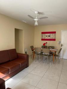 sala de estar con sofá, mesa y sillas en Apartamento Cabo Frio - 2 quartos en Cabo Frío