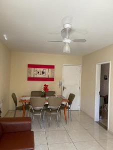 uma sala de jantar com uma mesa e cadeiras e uma ventoinha de tecto em Apartamento Cabo Frio - 2 quartos em Cabo Frio