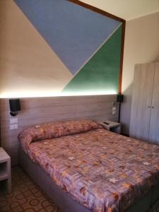 1 dormitorio con 1 cama con una pintura en la pared en Cannone d'Oro, en Sale