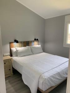 1 dormitorio con cama blanca y cabecero de madera en Casa ILEANA, en Sanlúcar de Barrameda