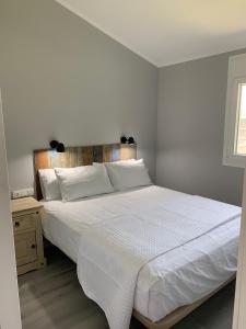 a bedroom with a white bed with a wooden headboard at Casa ILEANA in Sanlúcar de Barrameda