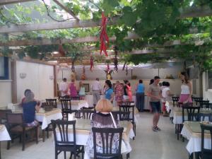 a group of people sitting at tables in a restaurant at Kleopatra Sahara Hotel in Alanya