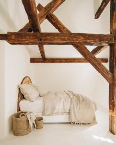 a bed in a white room with wooden beams at V Bezovém Údolí in Kryštofovo Údolí