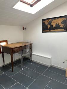 Zimmer mit einem Holztisch an der Wand in der Unterkunft Calm Loft Gare Sncf Toulouse centre in Toulouse