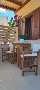 una mesa de madera y bancos en un patio en Kallistis Beach House en Monólithos