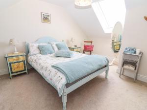 a bedroom with a bed and two tables and a mirror at Lynchpin Cottage in Bruff