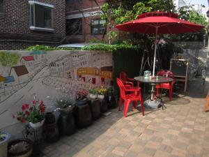 a patio with a table and chairs and an umbrella at Appletree Guesthouse in Seoul