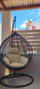 a hanging chair with pillows on a porch at Kallistis Beach House in Monolithos