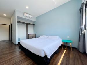 a bedroom with a large bed and a green table at Roxy Sematan Beach Townhouse Deluxe 7 ,8 ,9 in Sematan