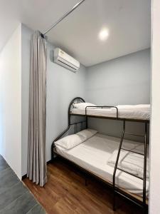 Pokój z 2 łóżkami piętrowymi i oknem w obiekcie Roxy Sematan Beach Townhouse Deluxe 7 ,8 ,9 w mieście Sematan