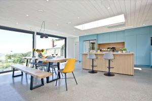 a dining room with a table and chairs and a kitchen at Rockpools in Newquay Bay Resort