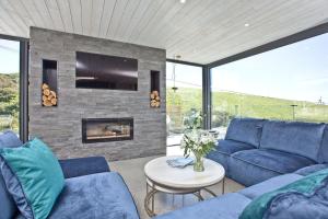 a living room with a blue couch and a fireplace at Rockpools in Newquay Bay Resort