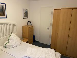 a bedroom with a bed and a dresser and a door at Seeblick Wohnung 115 in Ostseebad Koserow