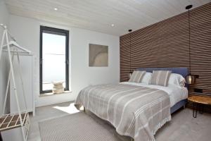 a bedroom with a large bed with a wooden headboard at Rockpools in Newquay Bay Resort