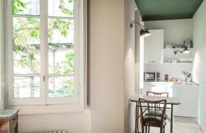 cocina con mesa, sillas y ventana en Brera Apartments in Porta Romana, en Milán