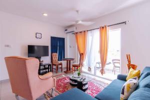 uma sala de estar com um sofá azul e uma televisão em Fumbatown Cozy 1 bed Apartment em Fumba