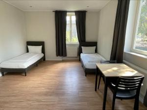 Cette chambre comprend 2 lits et une table. dans l'établissement Ahoi Hostel, à Hambourg