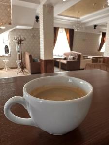 uma chávena de café sentada em cima de uma mesa em Premiera em Svalyava
