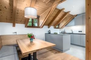 a kitchen with wooden ceilings and a wooden table at Apartments Perfila Dolomitenblick in Valdaora