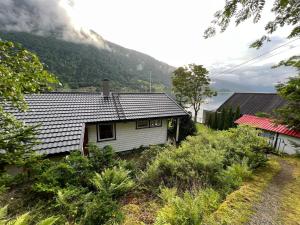 バレストランドにあるNorwegen - Traumhaus direkt am Fjordの山を背景にした小さな白い家