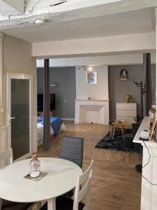 uma sala de estar com uma mesa e um quarto em Appartement de caractère hyper centre em Ploërmel