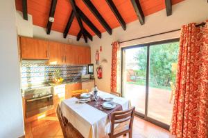 a kitchen with a table and a large sliding glass door at Pedras D'el Rei in Tavira