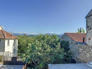ein Gebäude mit einem Baum neben einem Gebäude in der Unterkunft Maison Vue Pyrénées Centre ville - salle de jeux in Saint-Gaudens