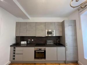 a kitchen with white cabinets and stainless steel appliances at Eclectic 2BR with shared terrace perfect getaway in Gibraltar