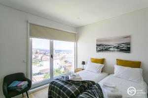 a bedroom with two beds and a large window at Home Azores - Casas da Ladeira in Ponta Delgada