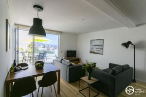 uma sala de estar com um sofá e uma mesa com cadeiras em Home Azores - Casas da Ladeira em Ponta Delgada