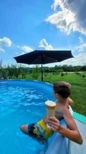 a young boy sitting on a raft in a swimming pool at Sunny Funny House in Čačak