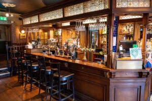 bar w pubie z stołkami w obiekcie Hampton Hotel by Greene King Inns w Edynburgu
