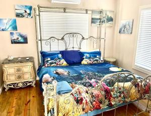 Schlafzimmer mit einem Metallbett mit blauer Decke in der Unterkunft Hummingbird in Utila