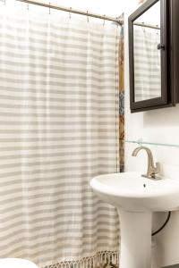 a bathroom with a sink and a shower curtain at The Spanglish Rooftop Garden Modern Historical in Dearing