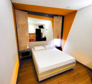 1 dormitorio con 1 cama blanca en una habitación en Motel Caribe, en Belo Horizonte