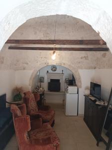 a living room with an archway with chairs and a television at Trulli Belvedere in Putignano