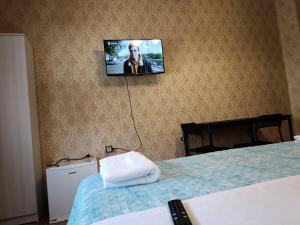 una televisione appesa a un muro in una camera da letto di Locazione Turistica a Tessera