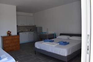 a small bedroom with a bed and a kitchen at Anastasias apartments in Sarandë