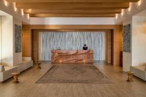a person sitting at a desk in a lobby at Angsana Corfu Resort & Spa in Benitses