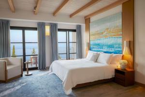 a bedroom with a large bed and a large window at Angsana Corfu Resort & Spa in Benitses