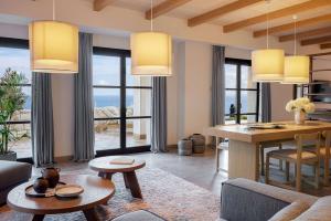a living room with a table and a dining room at Angsana Corfu Resort & Spa in Benitses
