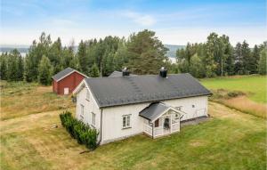 uma casa branca com um telhado preto num campo em 3 Bedroom Lovely Home In Grue Finnskog 