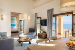 Angsana Corfu Resort & Spa في بينيتسيس: غرفة معيشة مع أريكة وطاولة