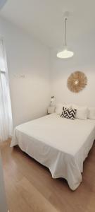 1 dormitorio blanco con 1 cama blanca grande en una habitación en La buhardilla, en Sevilla