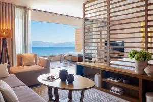 a living room with a couch and a table at Angsana Corfu Resort & Spa in Benitses