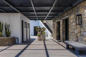 a hallway with a bench and a brick wall at Noima Boutique Hotel Mykonos in Agios Ioannis Mykonos