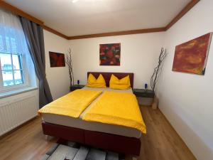 1 dormitorio con 1 cama con manta amarilla en Villa Mercedes, en Tobaj