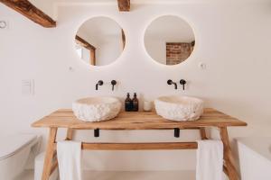 two sinks on a wooden table in a bathroom with mirrors at V Bezovém Údolí in Kryštofovo Údolí