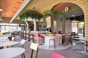 restauracja ze stołami i krzesłami oraz bar w obiekcie greet hotel Cernay Mulhouse w mieście Cernay